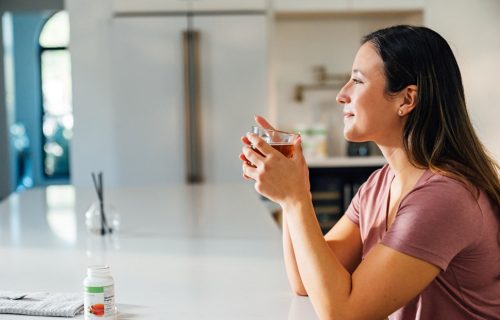 A woman drinking a cup of Herbal Tea Concentrate.