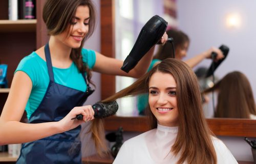 female-hairdresser-using-hairbrush-hair-dryer